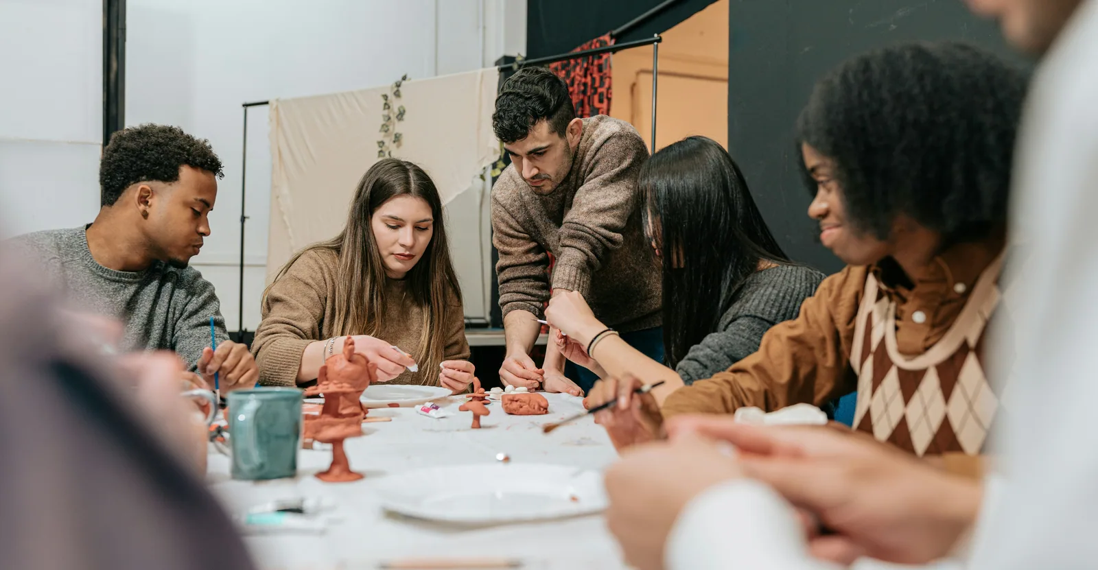 A mixed group working together around a workshop table