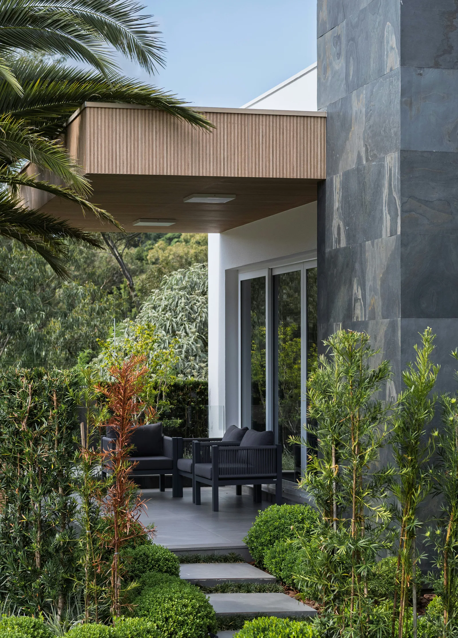 Modern patio with outdoor seating and lush greenery
