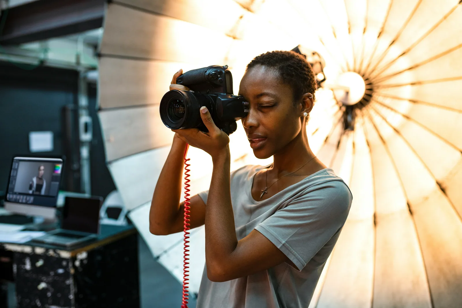 A photographer with a camera in front of a reflective umbrella