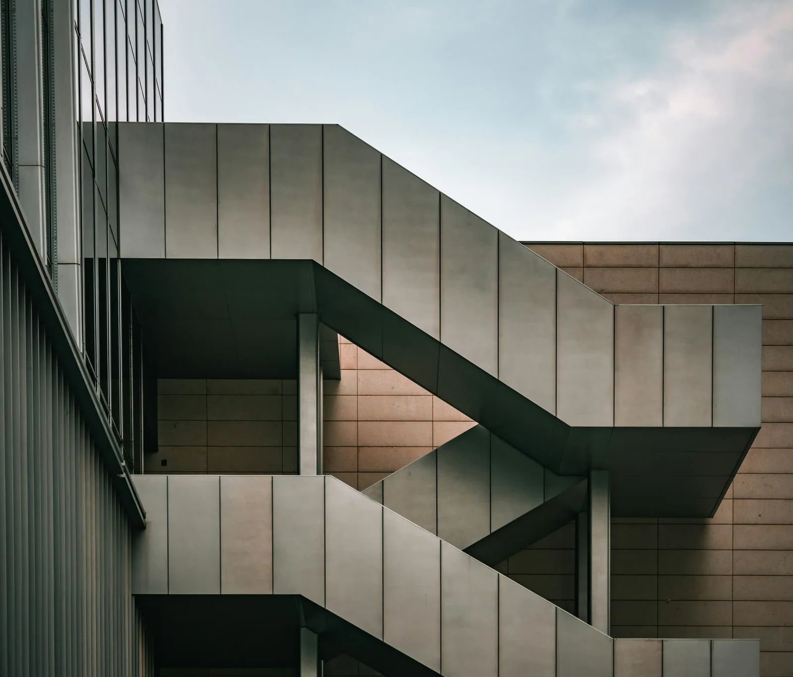 A tall building with a spiral staircase next to it