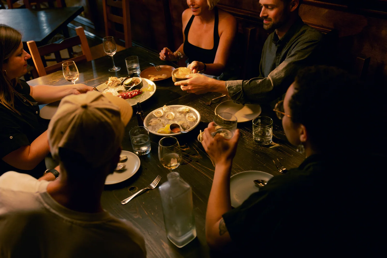 Friends around a dinner table in low evening light