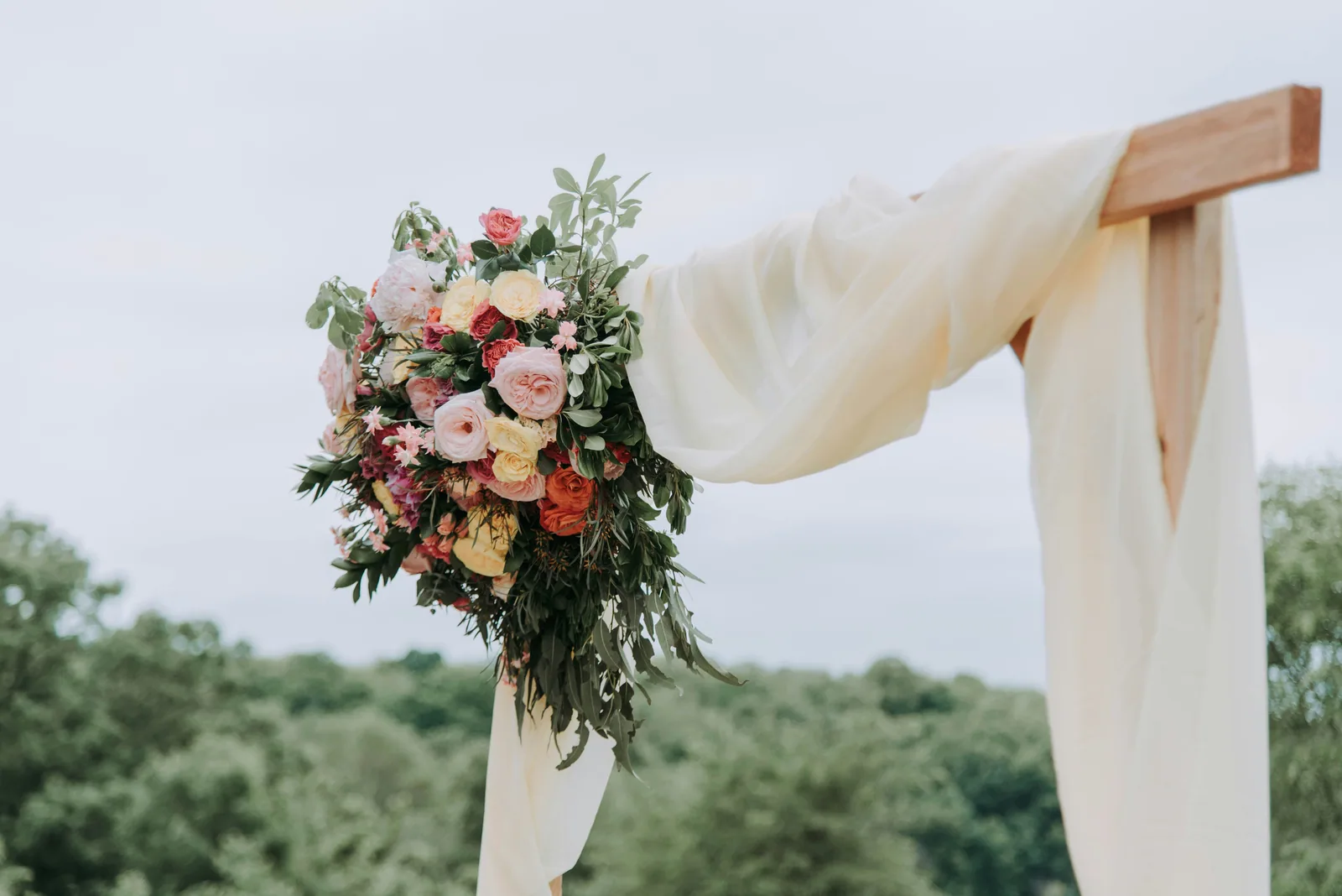 Bouquet of assorted-color flowers hanged on brown plank with white