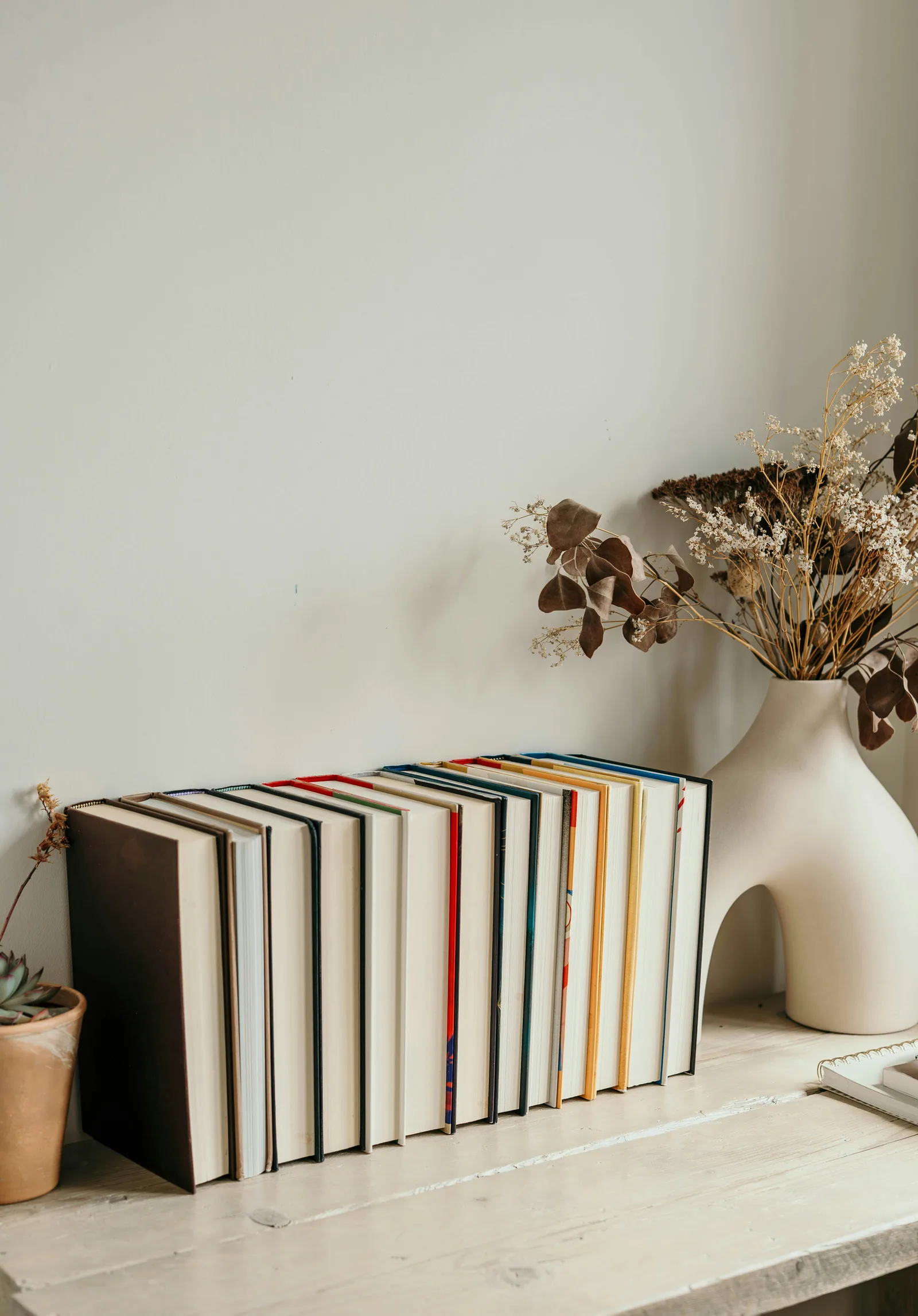A table topped with books and a vase filled with flowers