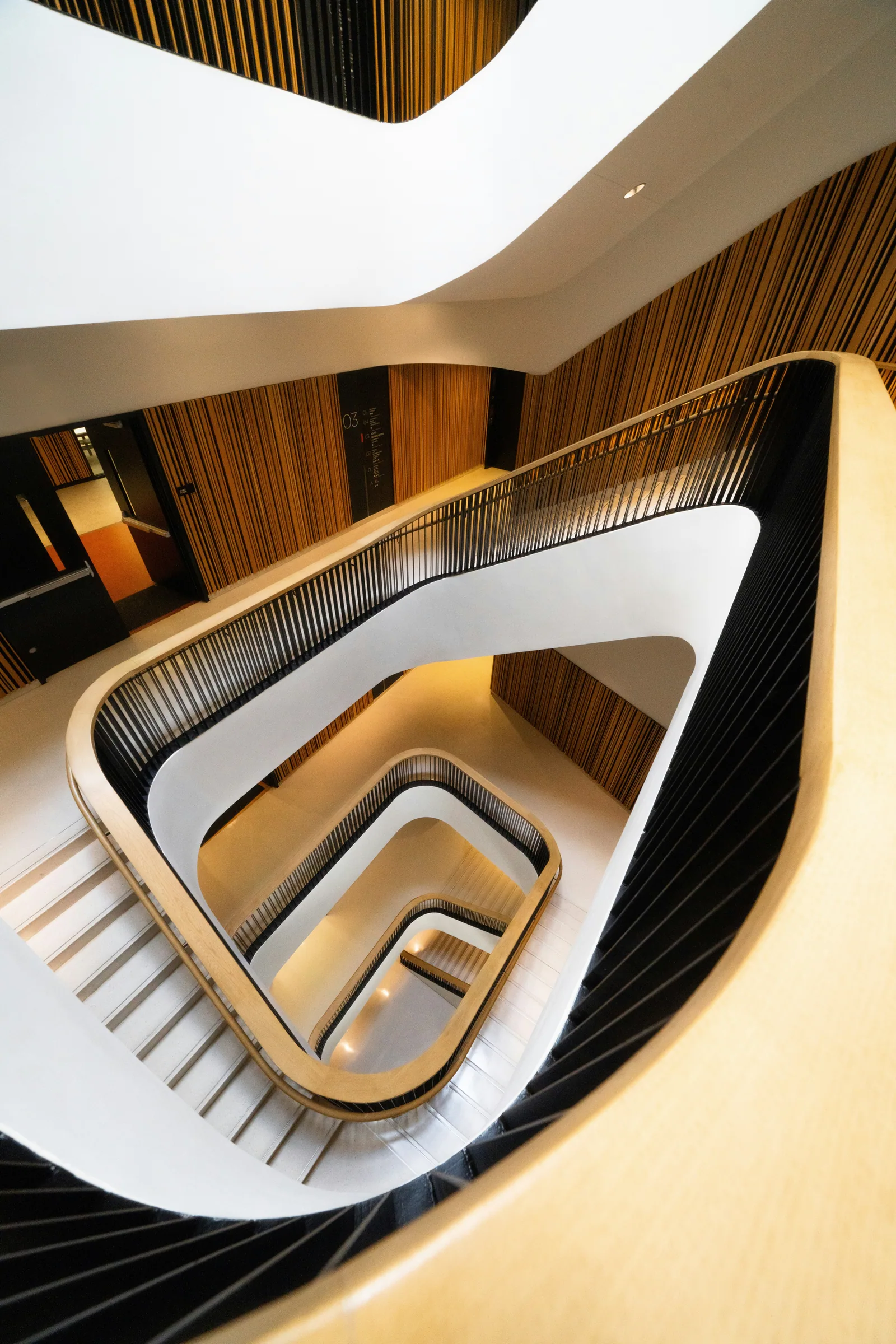 A spiral stair in white and pale wood, seen from above