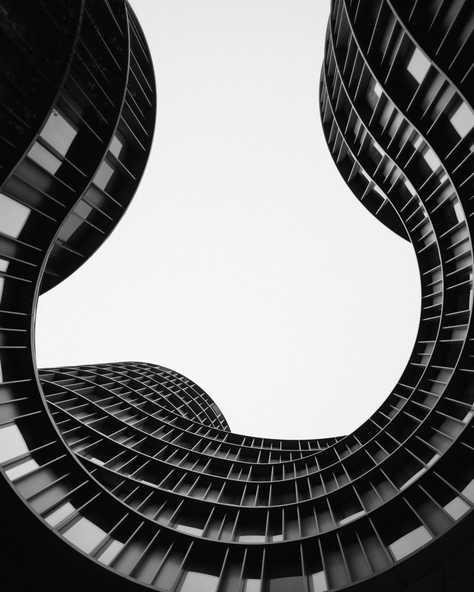Black and white towers curving up around an open sky