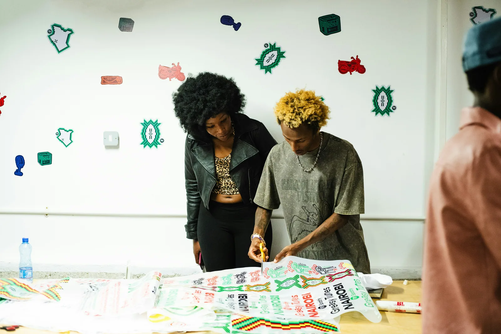 Two designers working on a bold printed pattern laid out on a table