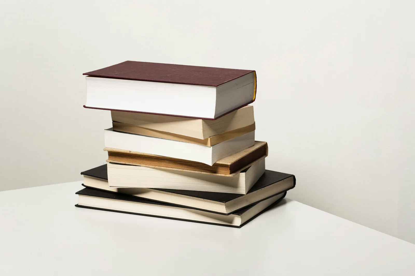 A neat stack of cloth-bound books on a white table