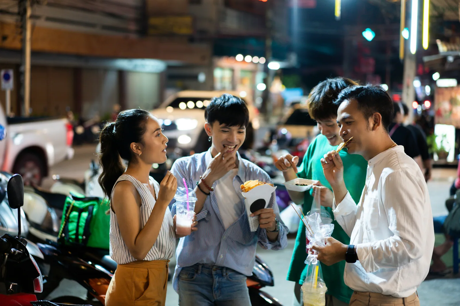 Friends sharing street food at an evening market