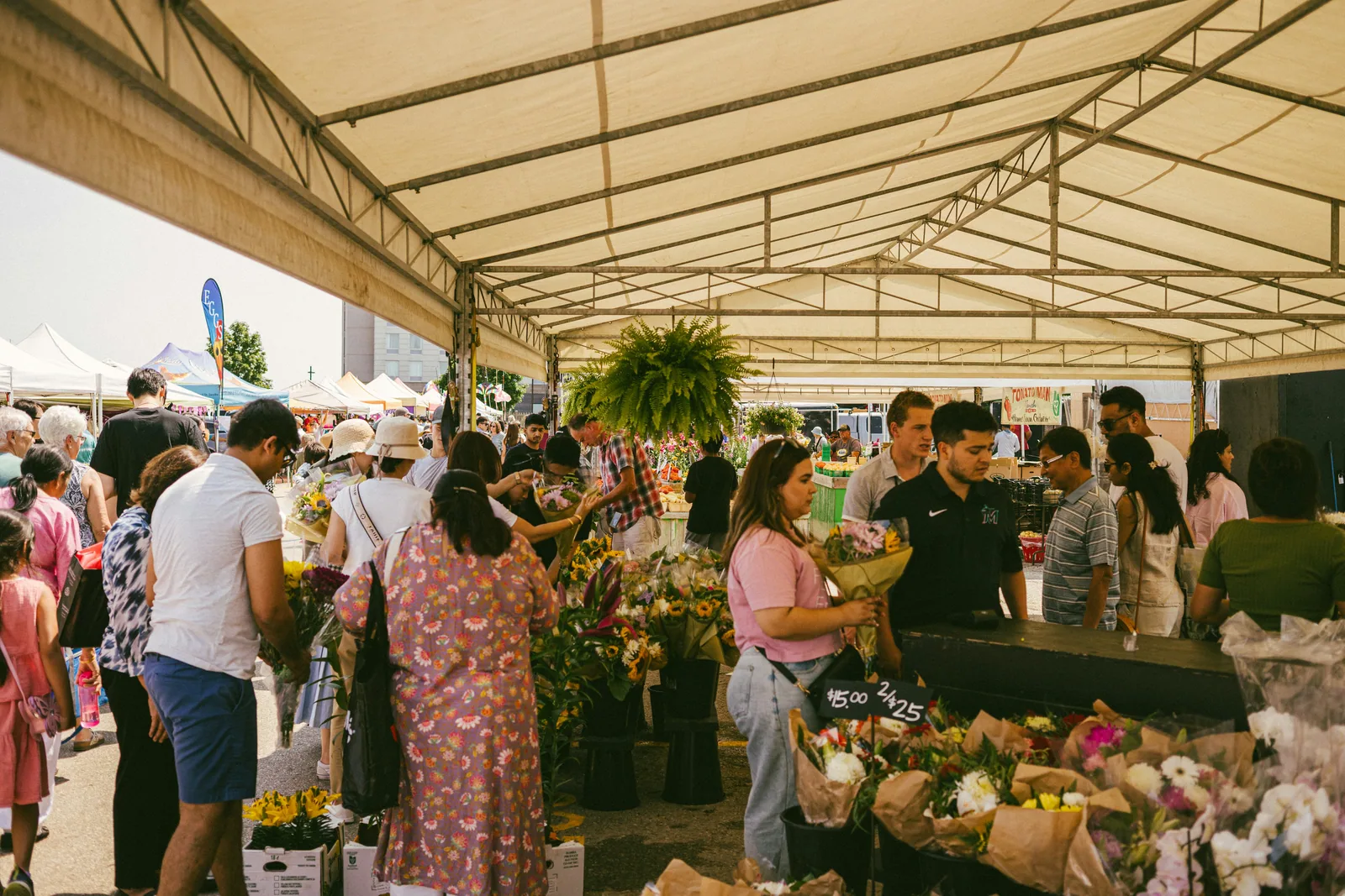People browsing flowers and plants at an outdoor market