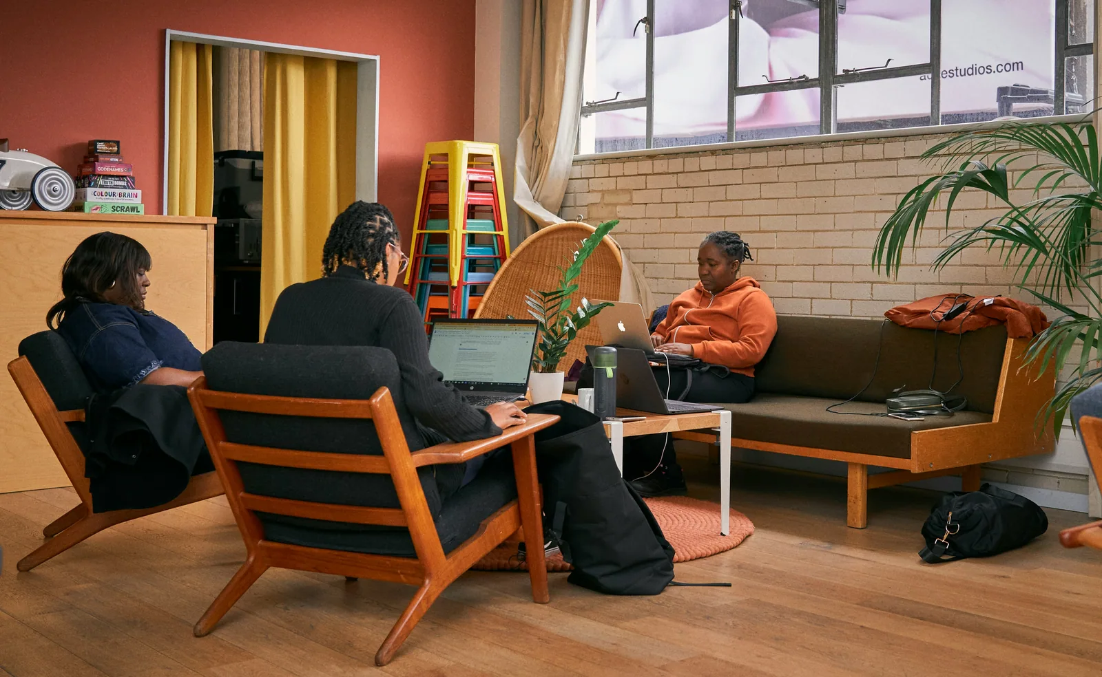 A small group meeting in a lounge with wooden chairs