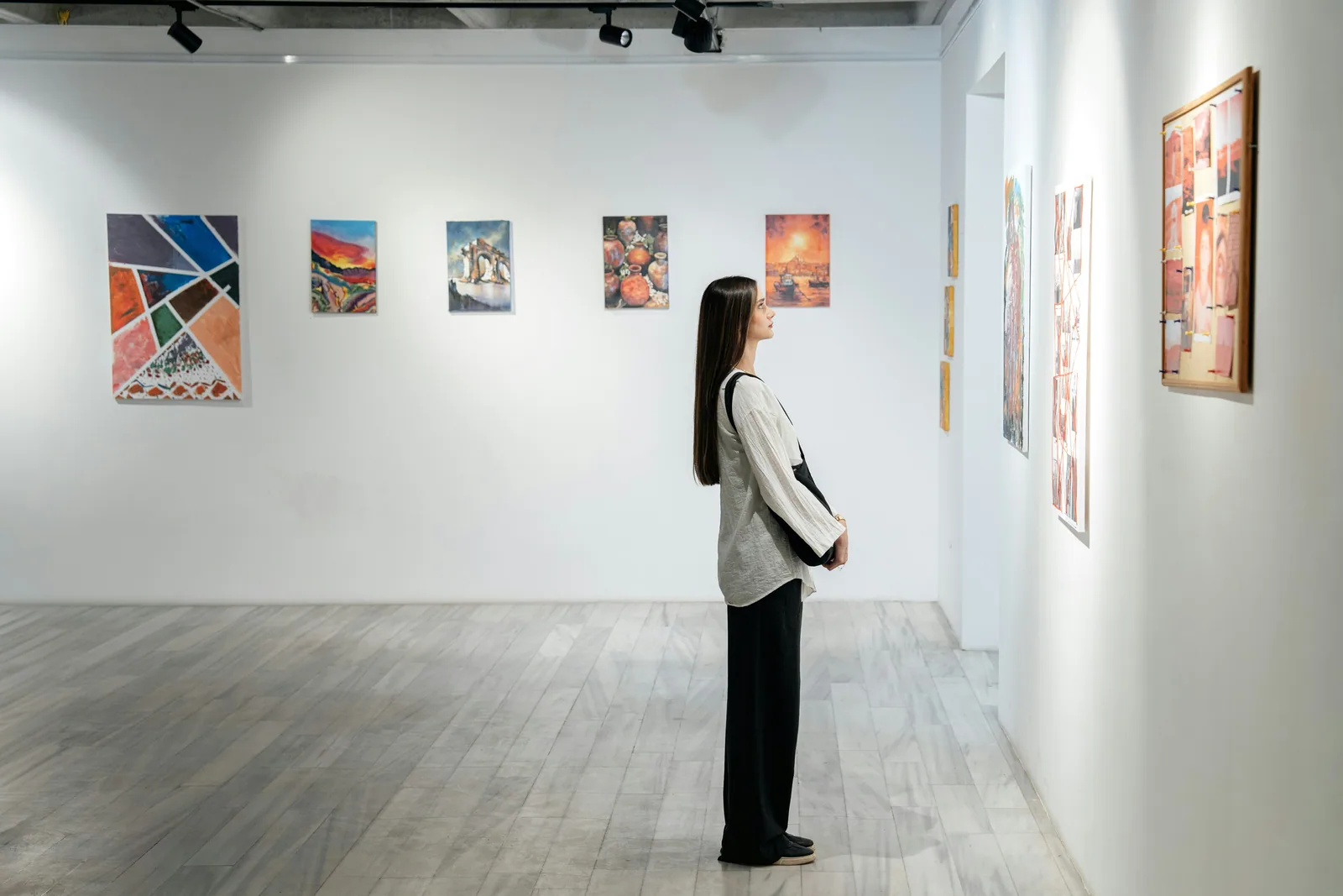 A visitor looking at art in a white gallery