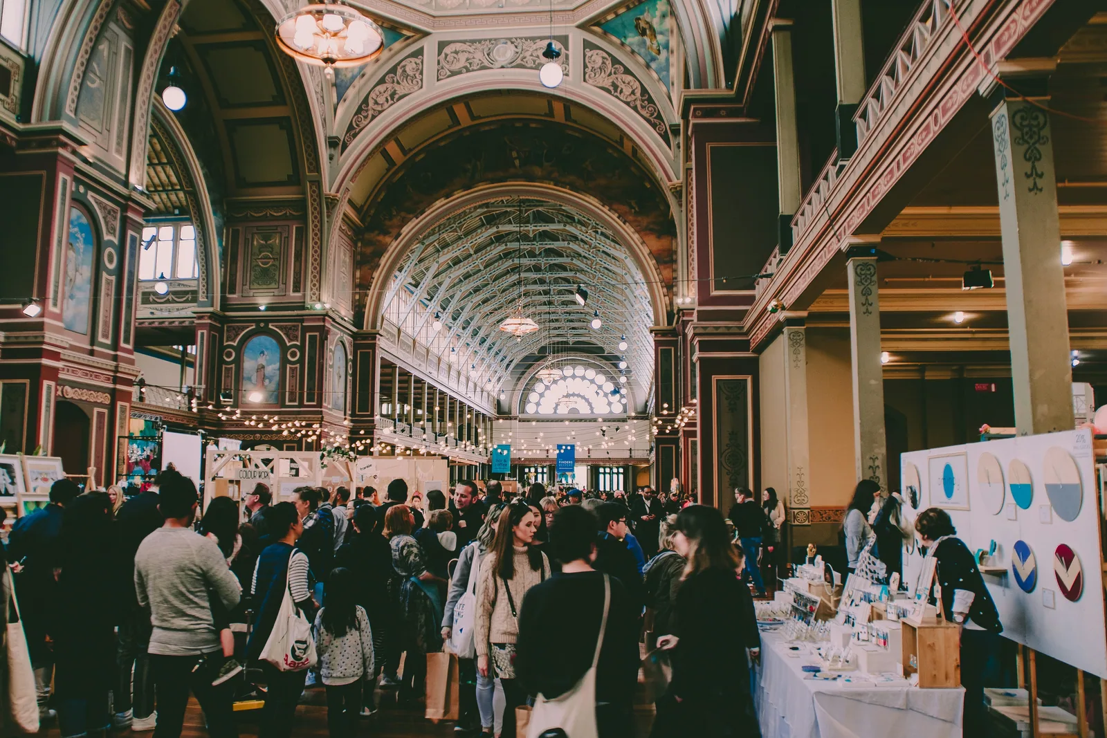 A busy market hall with stalls under a glass roof