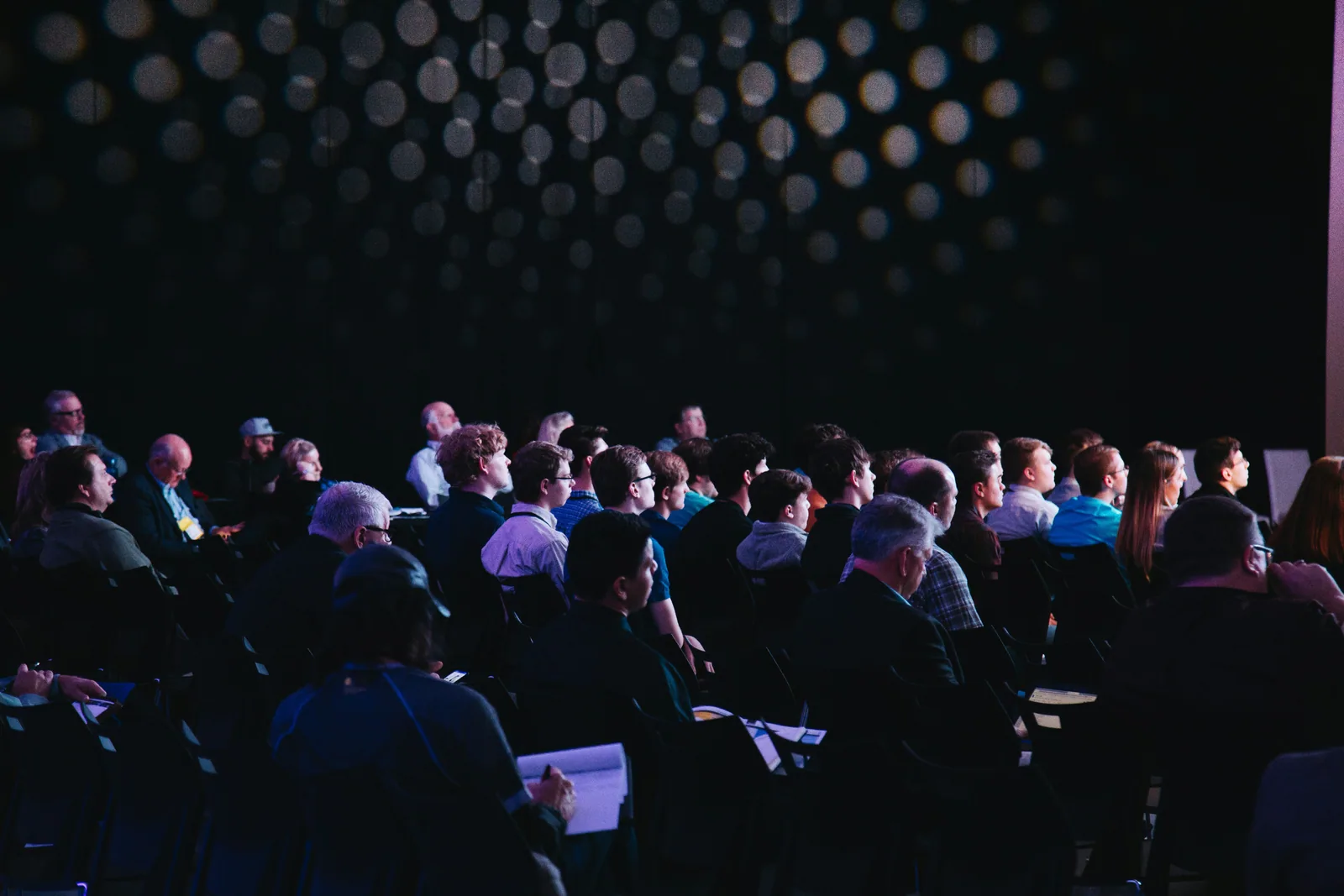 A seated audience in a dark room