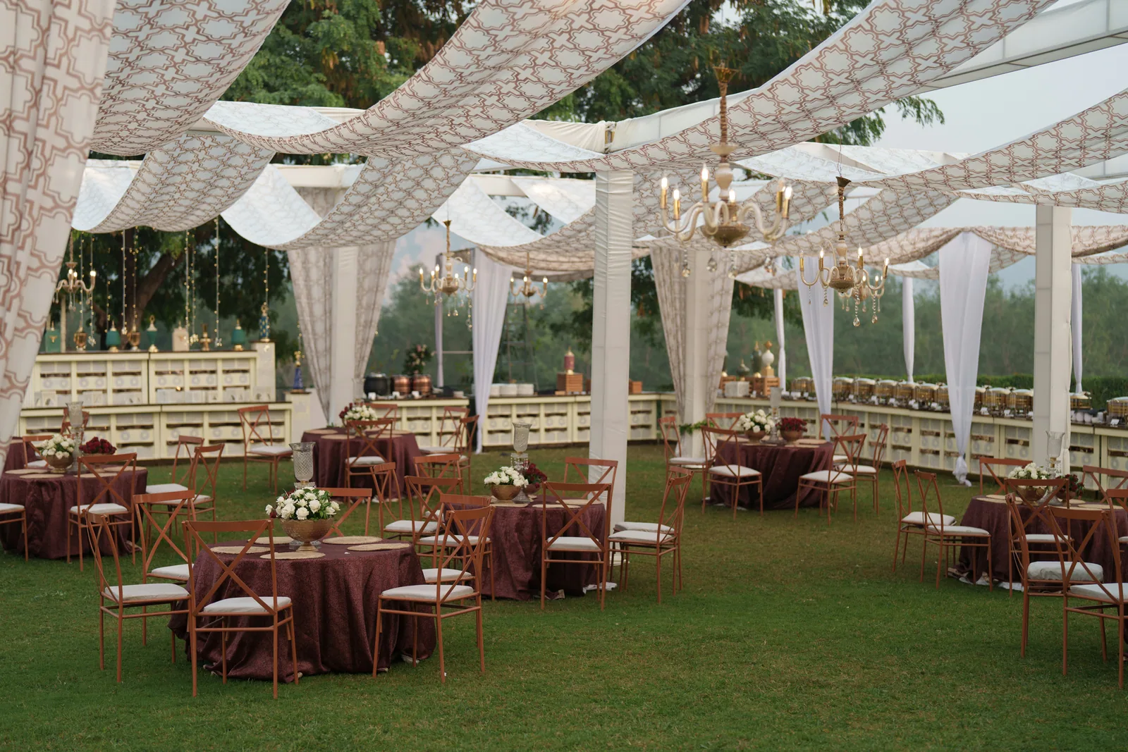 Round tables under a draped canopy outdoors