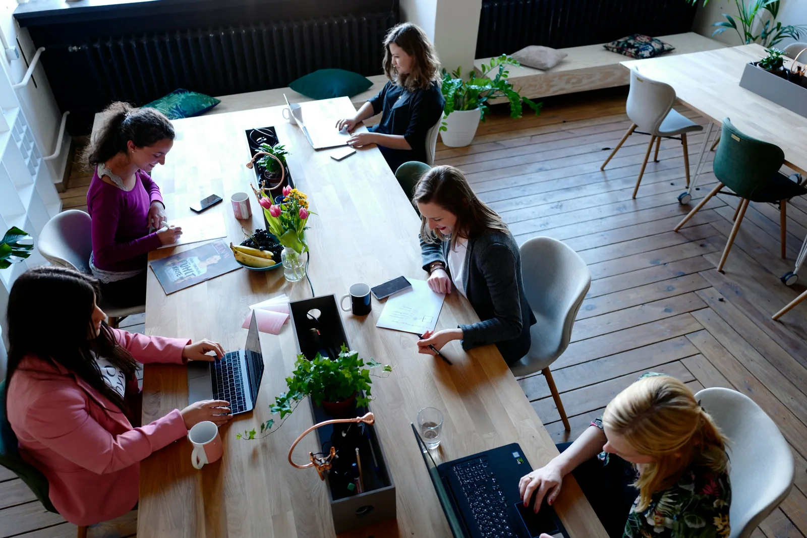 A team working around one long wooden table, seen from above