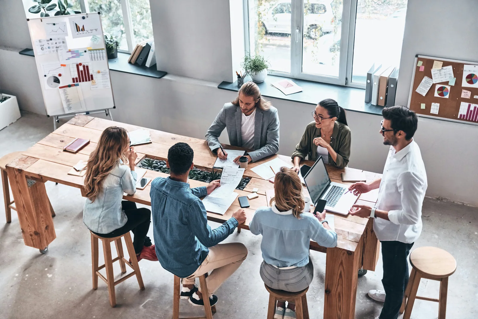 A team meeting at a large table, seen from above