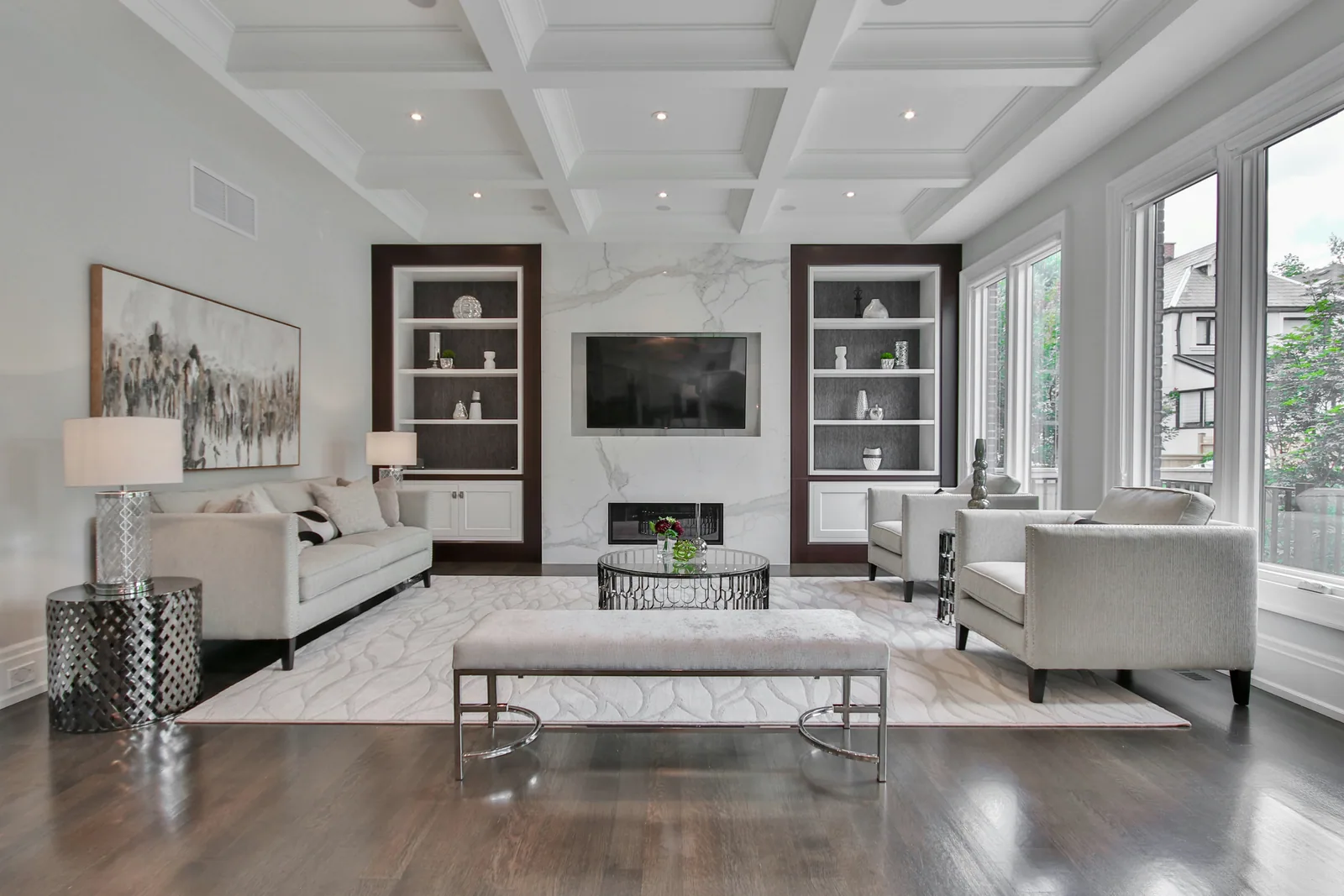 A formal living room with a marble fireplace and a coffered ceiling