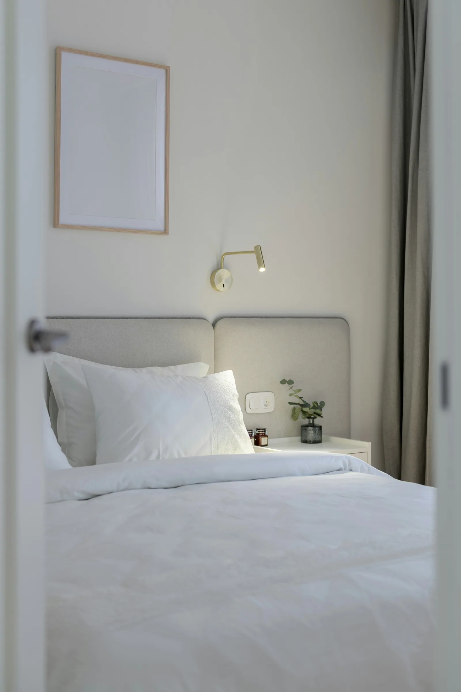 A white bedroom with an upholstered headboard