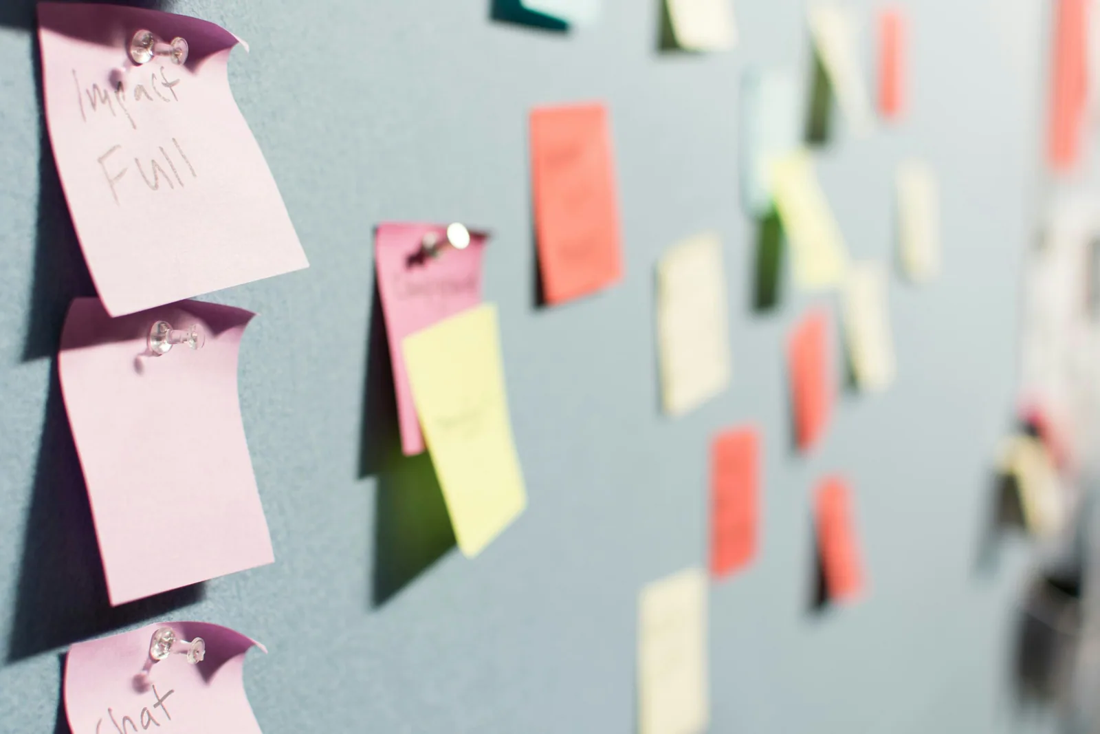 Sticky notes pinned to a grey board