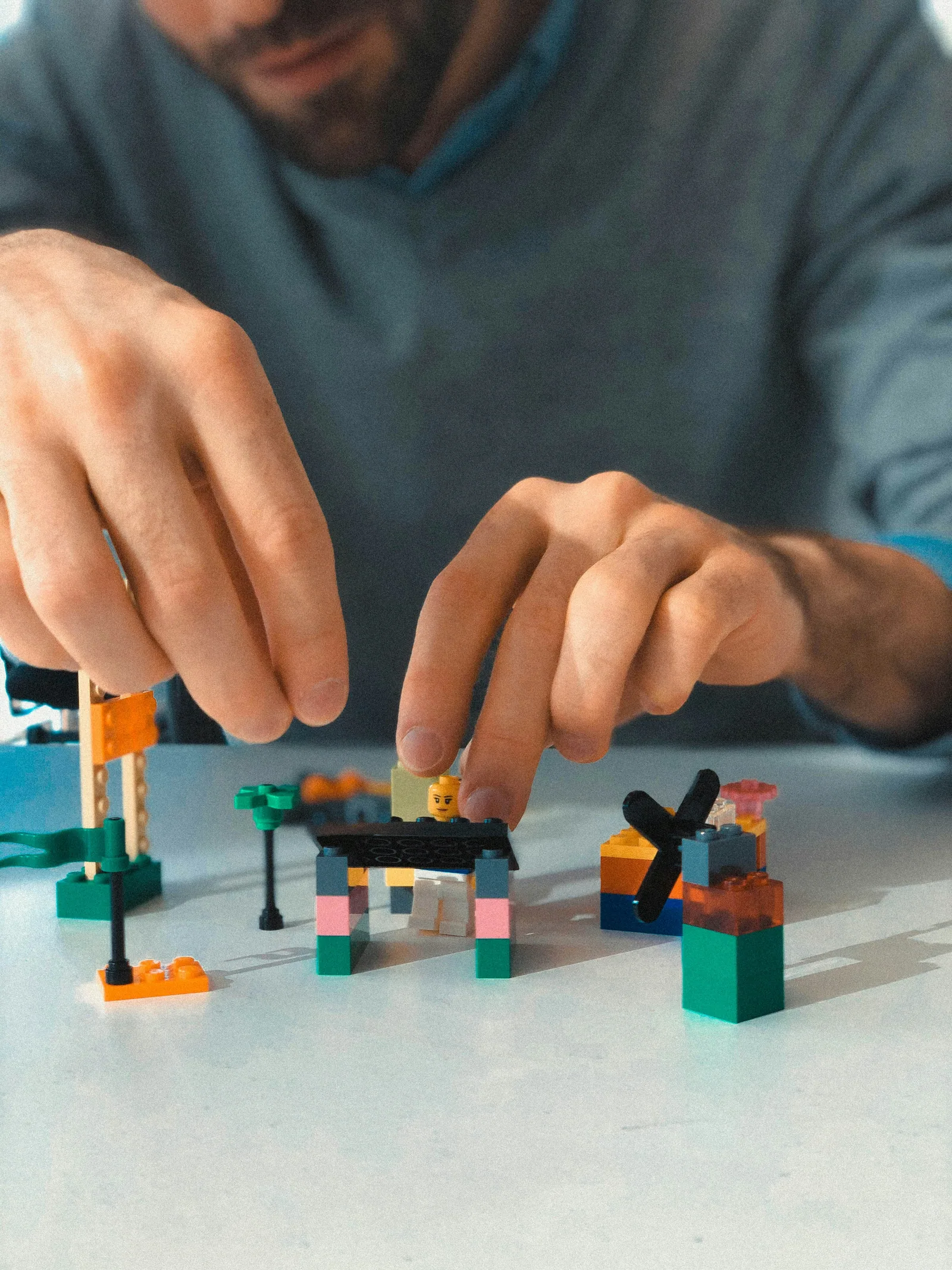 Hands building a small model from toy bricks