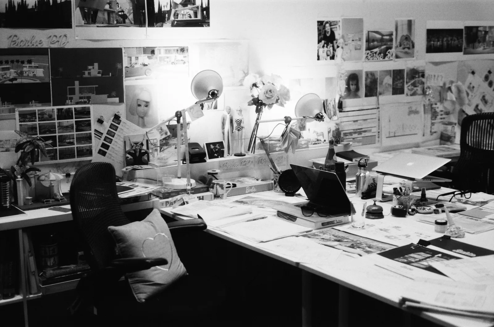 A busy black and white studio wall covered in pictures